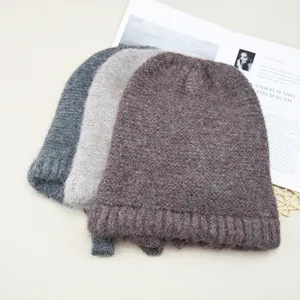 Detailed shot of solid color wool knit beanies with ties, warm and cozy winter headwear.