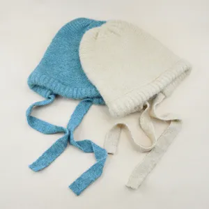 Knit beanie hat detail view, soft woolen material with adjustable long strap ties for women.