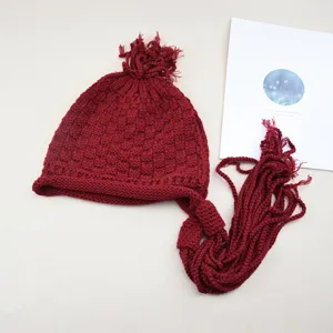 Berretto in maglia rosso scuro con lunghe nappe intrecciate, cappello invernale retrò.