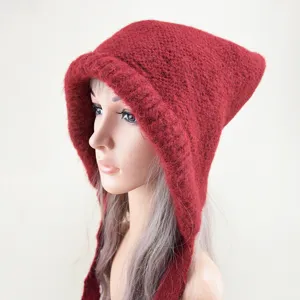 Detailed close-up view of the dark red knitted hooded hat, showing fine wool texture and ties.