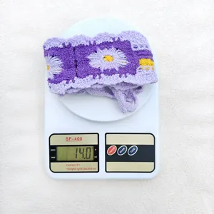 Häkeln Strick Stirnband Detailansicht Gewicht auf Waage, lila Blumenmuster Design.