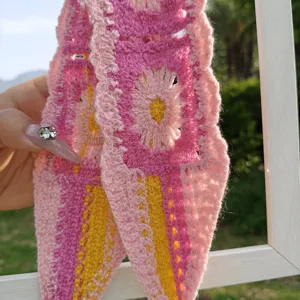 Detailansicht des bunten Häkelstirnbandes mit Blumenmuster und lockerem Strickdesign für Damen.