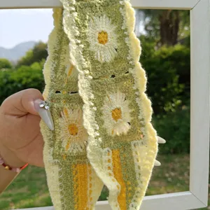 Detailansicht des handgemachten Häkel-Blumen-Stinrbands in Grün und Gelb mit Lochmuster.