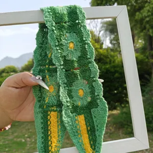 Detailaufnahme des handgefertigten grünen Häkelblumen-Stirnbands im schönen Landhausstil.