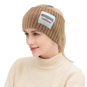 Nahaufnahmedetail des braunen Strick-Ohrwarmer-Stirnbands mit dekorativem Textetikett.