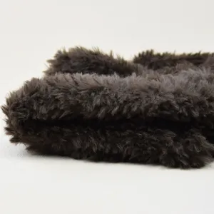 Close-up detail van zachte bruine pluche imitatiebont stof, donsachtige textuur, winter accessoire.