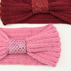 Detailed shot of winter knitted headband with sequin bow knot, elastic ear warmer hair accessory.