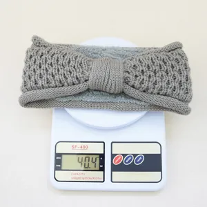 Vue detaillee du bandeau en tricot gris avec noeud et doublure, poids sur balance.