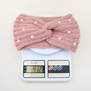 Primo piano del dettaglio fascia in maglia rosa con perle, peso esatto mostrato su bilancia.