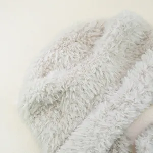 Close-up van de zachte beige imitatiebont pluche stof textuur, toont pluizige details.