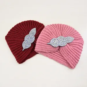 Detailed shot of autumn winter knitted turban hat with sparkling rhinestone leaf accessory warm.