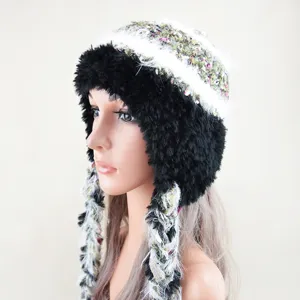 Detailed close-up of the plush knit winter hat with warm earflaps and stylish braided tassels.