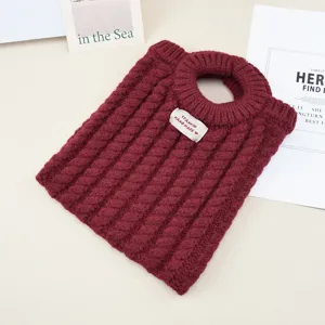 Nahaufnahme der dunkelroten Zopfmuster-Tasche mit weicher Strickstruktur und rundem Griff.