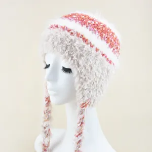 Detail view of the fluffy winter knit hat featuring colorful braided tassels and warm plush texture.