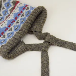 Detaillierte Nahaufnahme der Damen Strickmütze mit geometrischem Muster und Bindebändern.