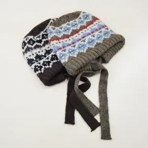 Detailansicht der Damen Strickmütze mit geflochtenen Bändern und norwegischem Jacquardmuster.
