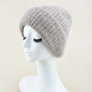 Detail view of cozy knit beanie hat in light brown, showing soft texture and folded cuff.
