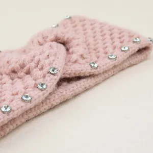 Nahaufnahme Detail eines rosa gestrickten Strass-Knotenstirnbandes mit feinen Kristallverzierung.