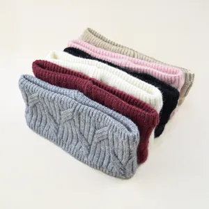 Close-up view of stacked knitted headbands in assorted colors, featuring warm fleece lining.