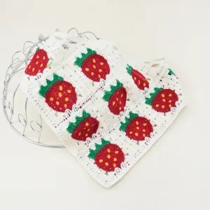 Détail de foulard triangulaire fraise au crochet, accessoire de bandana tricoté.