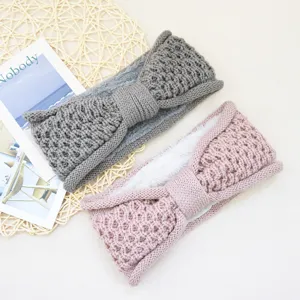 Gros plan de bandeau tricoté doux doublé de polaire avec nœud en gris et rose.