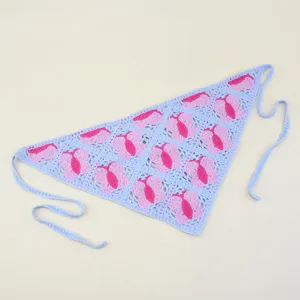 Détail de foulard triangulaire crocheté, bandeau tricoté bleu avec motifs de cœurs roses.
