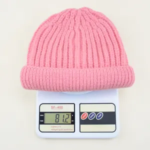 Roze gebreide kinder muts in detail op weegschaal, comfortabel winteraccessoire voor koude dagen