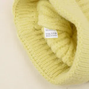 Detailopname van het zachte gebreide mutsetiket, 100% acryl materiaal textuur shot.
