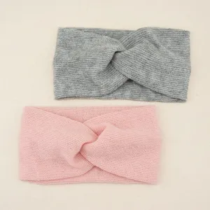 Detailed view of the soft knitted twist headband in grey and pink, elastic and comfortable.