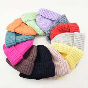 Closeup colorful knit beanie hats detail, soft warm winter pullover caps assorted colors.