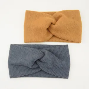 Detailansicht des weichen gestrickten Stirnbandes mit warmer Textur und elegantem Kreuzdesign.