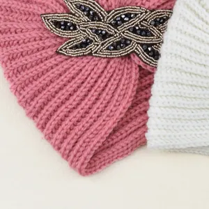Primer plano detallado de un gorro de punto de invierno con elegante decoración de cristales.