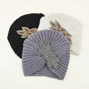 Vista detallada del elegante gorro turbante de punto con cuentas, opción de invierno cálida.