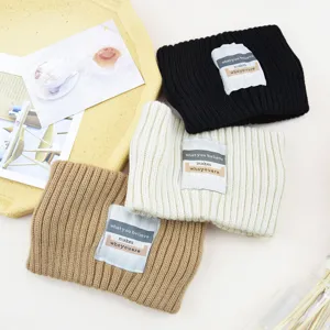 Detailansicht einfarbiger Strickstirnbänder mit Buchstabenetikett, warme Winter Haaraccessoires.