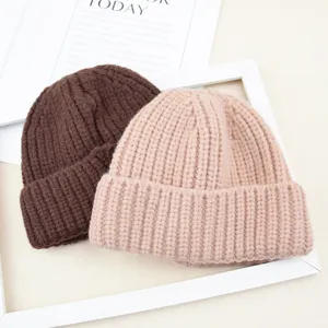 Detailed close-up view of warm chunky knit toddler beanie hats in brown and pink for winter.