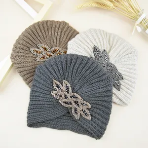 Vista detallada de los gorros turbante de punto con cuentas, ideales para el invierno.