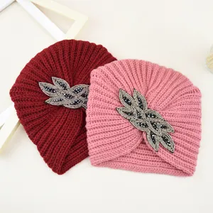 Vista detallada del gorro de punto con abalorios, finos detalles de cristal y textura suave.