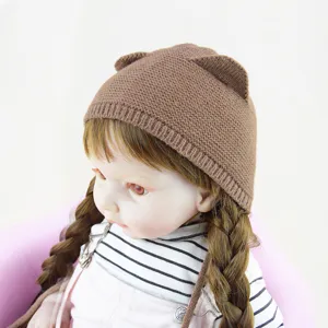 Schattige bruine gebreide baby muts met berenoren en gevlochten touwtjes voor warme wintertijden.