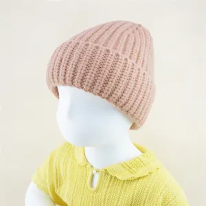 Children chunky knit beanie hat detail view, soft warm winter toddler cap in pink color.