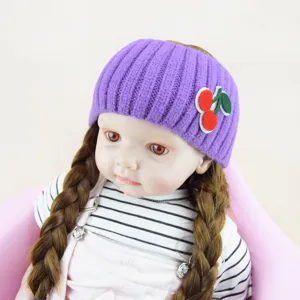 Primo piano della fascia in maglia viola con delizioso patch di ciliegia, accessorio morbido.