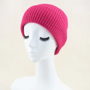 Primo piano del berretto in maglia a coste rosa vivo, mostra una trama fine e un polsino elegante.