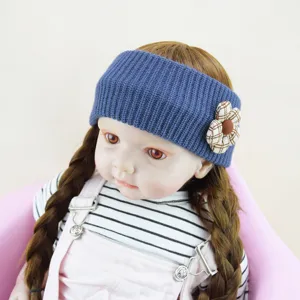 Detailed close-up view of a blue knitted baby headband featuring a cute plaid flower decoration.