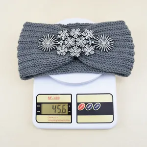 Vista dettagliata della fascia in maglia grigia con strass esposta su bilancia digitale.