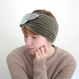 Close-up view of the knitted rhinestone leaf headband, showing delicate crystal texture details.