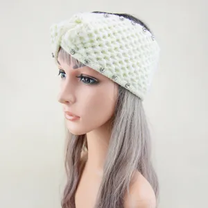 Detailansicht eines gestrickten Strass-Stirnbandes mit Kreuzdesign und funkelnden Kristallen.