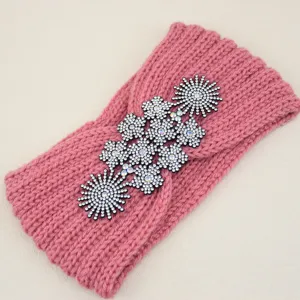Fascia per capelli in maglia rosa con accenti floreali in strass abbaglianti, accessorio elegante.