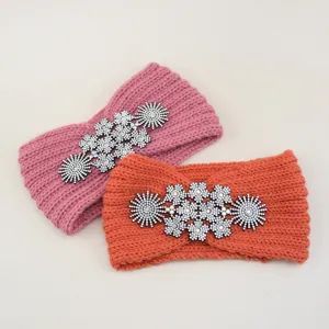 Dettaglio della fascia in maglia con decorazioni di fiori in strass e tessitura a costine.