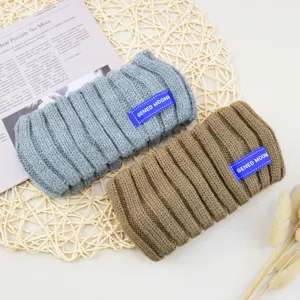 Gebreide geribbelde haarband detailweergave met grijze en bruine hoofdbanden met label.