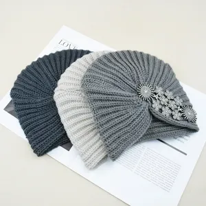 Winter warm knitted turban hat set with sparkling rhinestone floral detail for women.