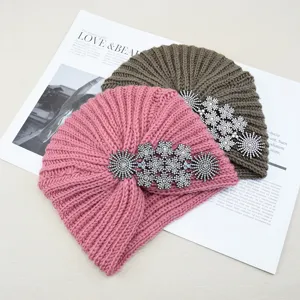 Detailed view of women winter knitted turban hat with sparkling rhinestone crystal flower charms.